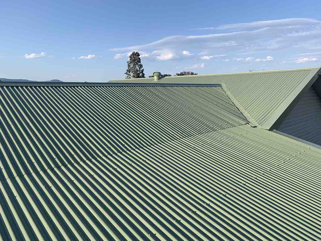 Pale green corrugated metal roof under a blue sky