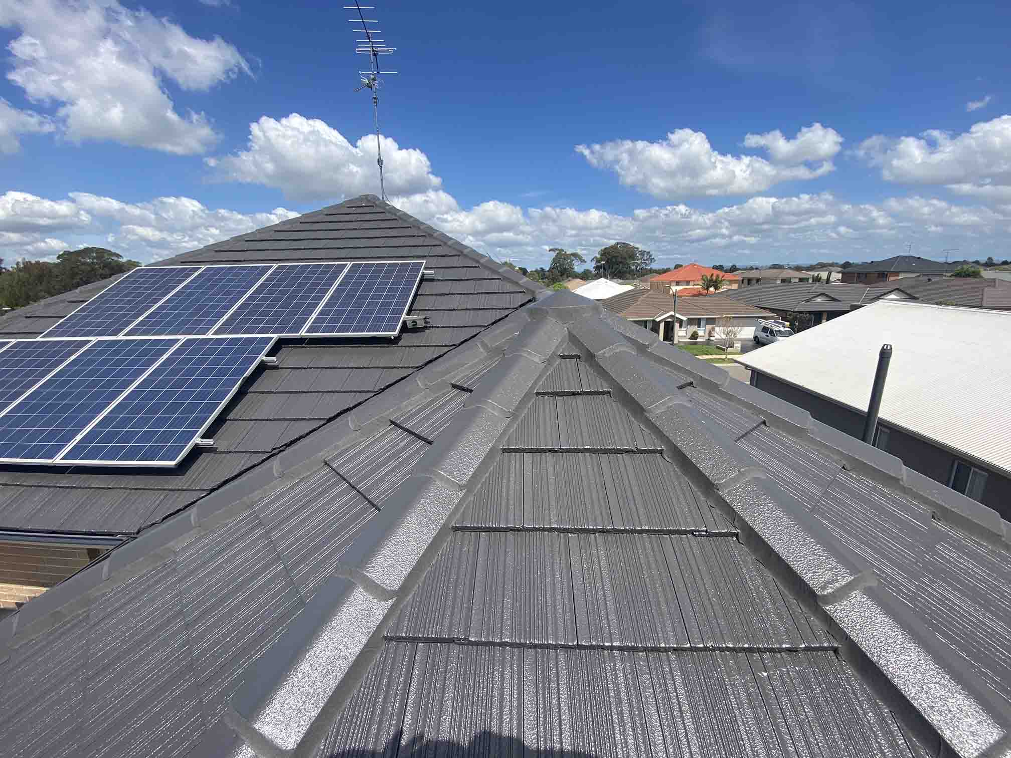 Grey tiled roof with solar panels and grey ridge capping